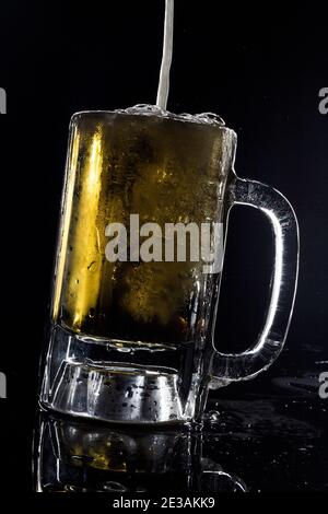 bière froide glacée pression de bière pression de keg studio encore vie sur un fond noir Banque D'Images