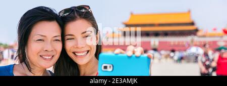 Asie voyage selfie en Chine. Des femmes chinoises touristes prenant des photos de téléphone autoportrait à la place Tiananmen vacances à Beijing. Bannière vacances d'été Banque D'Images