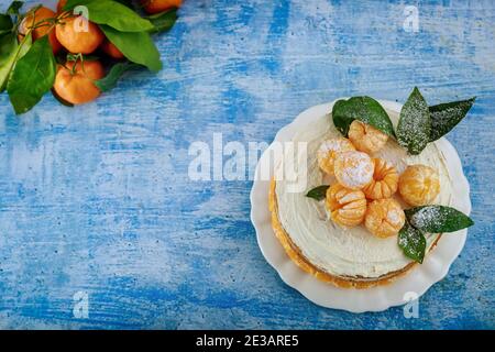 Tarte aux agrumes avec des feuilles et des mandarines fraîches. Vue de dessus. Banque D'Images