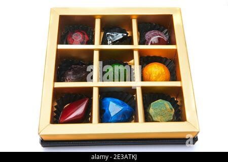 Bonbons au chocolat sous forme de pierres précieuses dans une boîte sur fond blanc. Cadeau pour la Saint-Valentin Banque D'Images