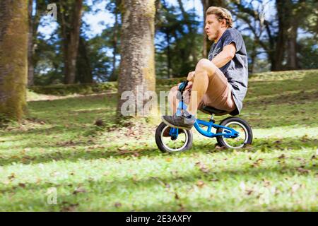 Descente amusante sur le vélo d'équilibre pour les petits enfants. Jeune homme fou qui descend d'une colline.