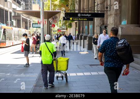 Employé de la poste en Australie avec chariot de livraison de courrier qui envoie le courrier Dans le centre-ville de Sydney, Nouvelle-Galles du Sud, Australie Banque D'Images