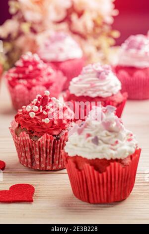 Carte de Saint-Valentin. Cupcake à la crème blanche et aux coeurs roses Banque D'Images
