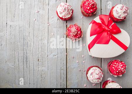 Boîte-cadeau et gâteau de Saint-Valentin décorés de crème et coeurs et perles sur fond blanc en bois avec espace de copie pour le texte Banque D'Images