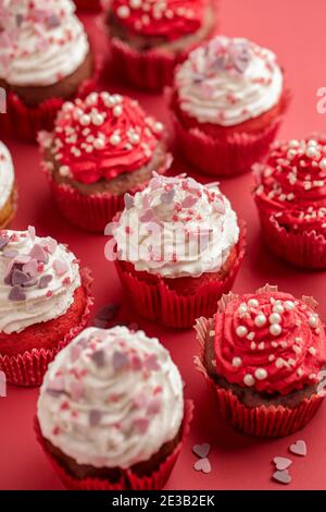 Carte de Saint-Valentin. Cupcake à la crème blanche et rouge et aux coeurs et perles roses Banque D'Images
