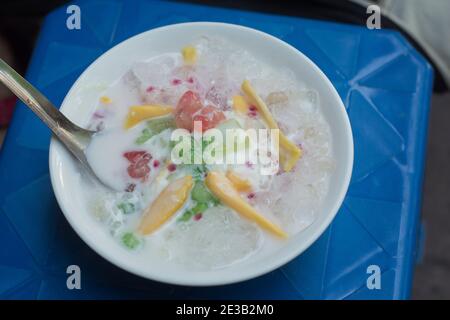 Cuisine de rue vietnamienne : dessert au pudding de tapioca froid avec lait de coco et gelées et fruits colorés, servis dans un bol, Hanoi, Vietnam Banque D'Images