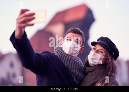 Couple heureux célébrant la Saint Valentin dans les masques pendant la pandémie de Covid-19 Banque D'Images