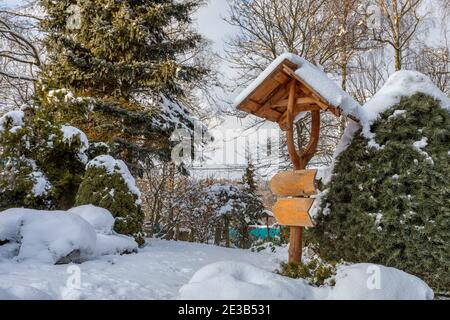 magnifique panneau en bois dans le jardin d'hiver recouvert de neige fraîche Banque D'Images