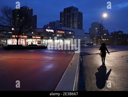 Leverkusen, Allemagne. 18 janvier 2021. Une femme marche dans le quartier de Chorweiler le matin. Dans la pandémie de Corona en Rhénanie-du-Nord-Westphalie, un indicateur important a légèrement diminué, mais il reste à un niveau élevé. La chancelière Merkel et les chefs de gouvernement des États fédéraux veulent discuter mardi (19.01.2020) d'un éventuel resserrement des règles de verrouillage. Credit: Oliver Berg/dpa/Alay Live News Banque D'Images