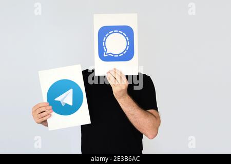 Homme portant deux cartes avec les logos Telegram et signal. Espace de copie vide pour le texte de l'éditeur. Banque D'Images