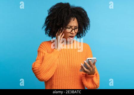 Confuse choqué Afro femme regardant le smartphone lisant de mauvaises nouvelles, notification, message désagréable Banque D'Images