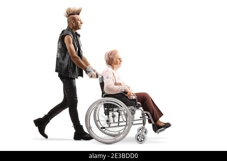 Punk rocker poussant une femme âgée dans un fauteuil roulant isolé sur fond blanc Banque D'Images
