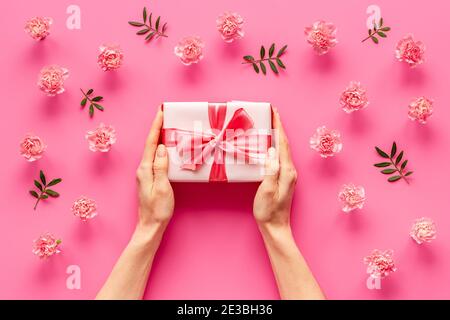 Boîte cadeau rouge entre les mains des femmes - célébration de la Saint-Valentin. Vue de dessus Banque D'Images