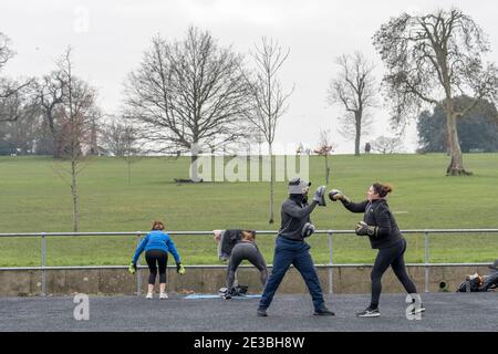 Un homme et une femme qui suivent un entraînement de boxe et une femme restent en forme à Brockwell Park le 15 janvier 2021 dans le sud de Londres, en Angleterre. Photo de Sam Mellish Banque D'Images