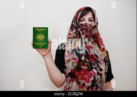 La jeune femme musulmane arabe vêtue de hijab tient le passeport du Turkménistan sur fond de mur blanc, portrait de studio. Banque D'Images