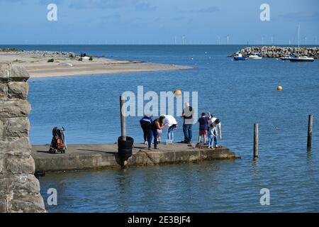 Une famille de touristes font la queue pour pêcher sur une jetée à Rhos-on-Sea, au nord du pays de Galles Banque D'Images
