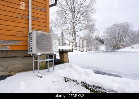 Pompe à chaleur air-eau près d'une ancienne maison en bois en hiver. Pompe à chaleur air-eau en gros plan Banque D'Images