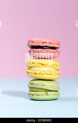 Macaron. Macarons traditionnels français colorés gros plan, macro sur fond bleu et rose Banque D'Images
