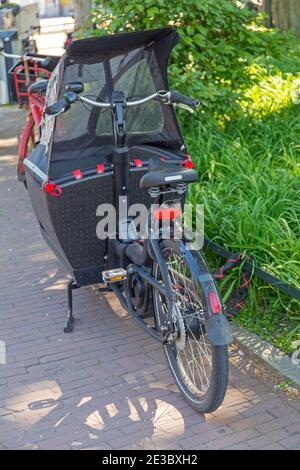 Vue arrière du vélo électrique avec cabine pour le transport des enfants Banque D'Images