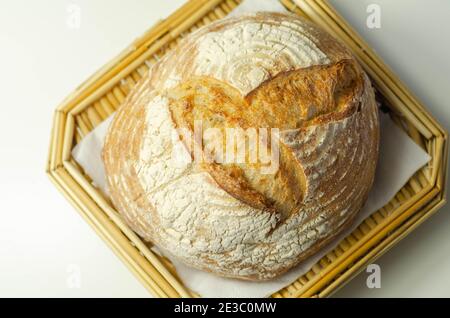 Pain rond traditionnel cuit selon une recette classique, servi sur un plateau en osier, boulangerie Banque D'Images