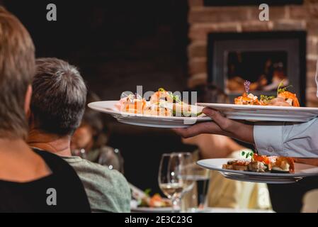 Le serveur sert un plat pour la dégustation de vins et de plats. En-cas avec crevettes, filets de poisson, Espagne tapas recette nourriture pintxos Banque D'Images