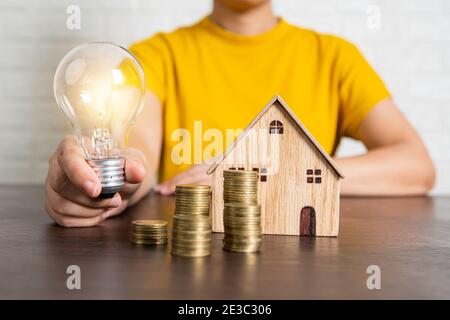 meilleure innovation et bon concept de propriété, agent de banque tenant l'ampoule lumineuse comme offre de financement de l'immobilier, maison et maison Banque D'Images