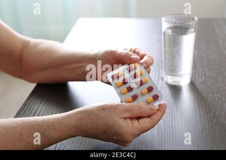 Pilules dans les mains de la femme âgée. Médicaments en capsules, prenant des sédatifs ou des vitamines Banque D'Images