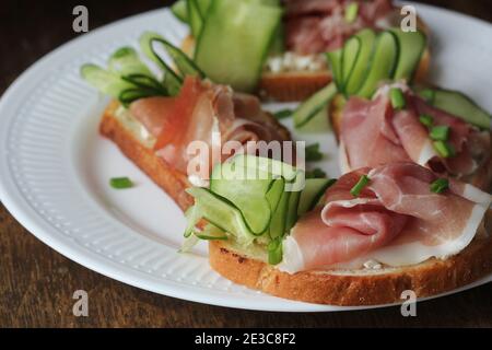 Hors-d'œuvre italienne traditionnelle bruschetta de pain grillé avec ricotta, concombre et prosciutto Banque D'Images