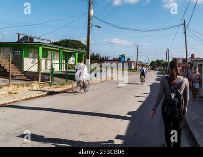 Photo d'une rue dans une petite ville de Cuba, avec peu de personnes dans la rue en période de pandémie, deux hommes sont à vélo et deux femmes marchent Banque D'Images