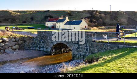 PORTSOY ABERDEENSHIRE SCOTLAND GENS TRAVERSANT LE PETIT PONT AU-DESSUS DE LA FEU DE DURN LA VOILE LOFT BUNKHOUSE DERRIÈRE Banque D'Images