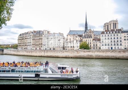 Les touristes explorant Paris à bord d'un bateau passant devant l'Île de la Cité, Paris Banque D'Images