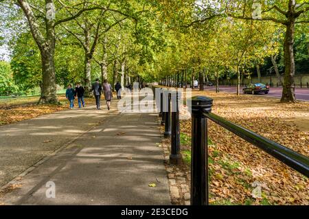 Les gens qui marchent le long de Constitution Hill au bord de Green Park à Londres pendant l'automne. Banque D'Images