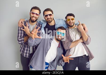 Groupe de jeunes amis en lunettes de soleil regardant l'appareil photo et poser pour une photo amusante Banque D'Images
