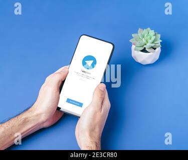 Melitopol, Ukraine - janvier 18 2021 : icône d'application de télégramme sur l'écran du smartphone. Réseau social sécurisé en ligne. Arrière-plan bleu Banque D'Images