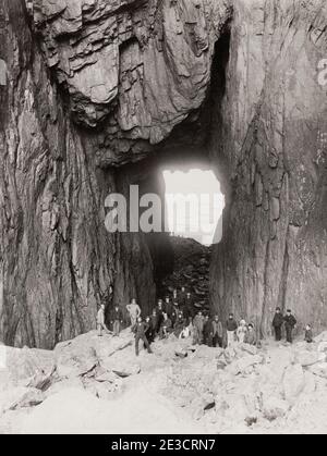 Photo d'époque du XIXe siècle : Torghatten est une montagne de granit sur l'île de Torget dans la municipalité de Brønnøy dans le comté de Nordland, en Norvège. Il est connu pour son trou caractéristique. Groupe de touristes. Banque D'Images