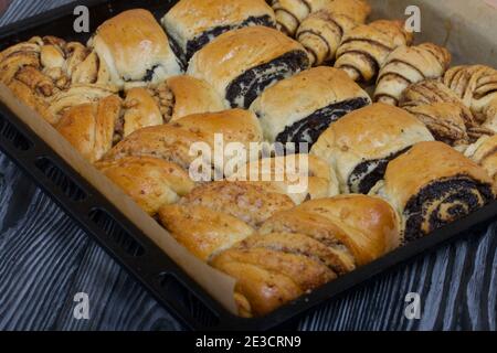 Pâtisseries riches. Les petits pains sont sur une plaque de cuisson. Remplissage avec des graines de pavot, des noix. Gros plan. Banque D'Images