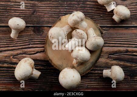 Champignons de Paris biologiques frais non cuits dans un plateau en bois Banque D'Images