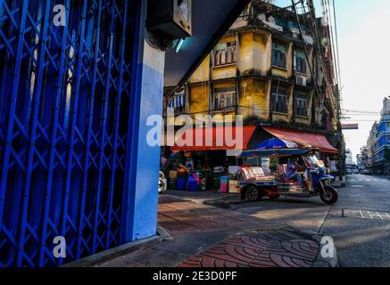 Un tuk-tuk bleu sort d'un carrefour à Chinatown, Bangkok, Thaïlande Banque D'Images