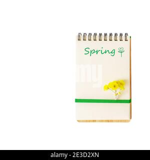 Cahier ouvert isolé avec une feuille blanche, le ressort d'inscription, l'espace de copie, les fleurs de printemps et avec l'inscription Spring sur un fond blanc. Banque D'Images
