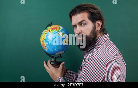 homme barbu mature enseignant en classe scolaire avec tableau noir, géographie. Banque D'Images