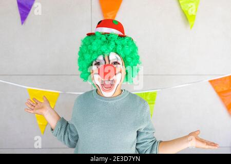 Petit garçon célébrant le carnaval à la maison habillé comme un clown Banque D'Images