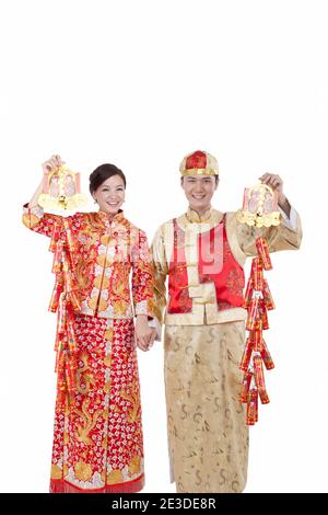 Portrait de jeune couple en costumes de Tang tenant des pétards, célébrant Banque D'Images