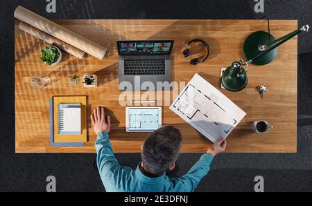 Vue de dessus d'un architecte travaillant sur un ordinateur au bureau à domicile, concept d'appel vidéo. Banque D'Images