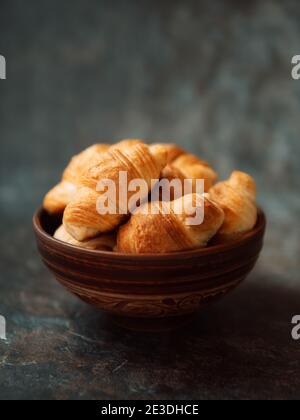 Croissants dans un bol en céramique sur fond sombre Banque D'Images