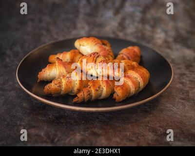 Croissants dans un bol en céramique sur fond sombre Banque D'Images