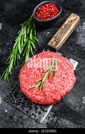 Hamburger Patty, viande de bœuf hachée. Arrière-plan noir. Vue de dessus Banque D'Images