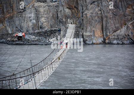 Photo aérienne d'un long pont suspendu au-dessus de l'eau menant à la montagne Banque D'Images