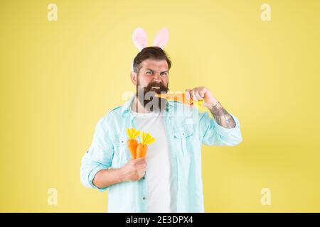 Faits nutritionnels et avantages pour la santé. La carotte se compose de vitamines. Heureux et en bonne santé. Lapin de Pâques contenir des carottes. Les oreilles de lapin d'homme barbu tiennent les légumes. Une alimentation saine. Régime végétarien. Pâques saines. Banque D'Images