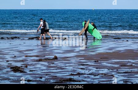 Surfeurs sur Belhaven Beach, près de Dunbar, East Lothian Banque D'Images