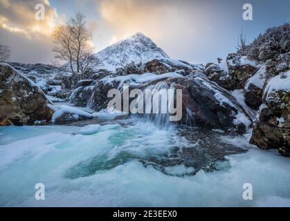 La rivière Frozen Coupall passe le long de Stob Dearg (le sommet le plus important de Buachille Etive More) lors d'une journée hivernale à Glencoe, en Écosse, au Royaume-Uni. Banque D'Images